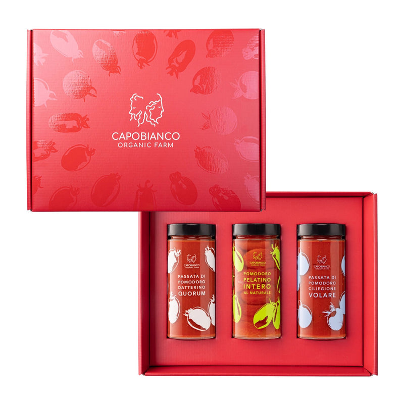 The Capobianco Vulcano Gift Box features a trio of organic tomato sauces and purees in glass jars—with unique, colorful labels—neatly displayed inside a red box.