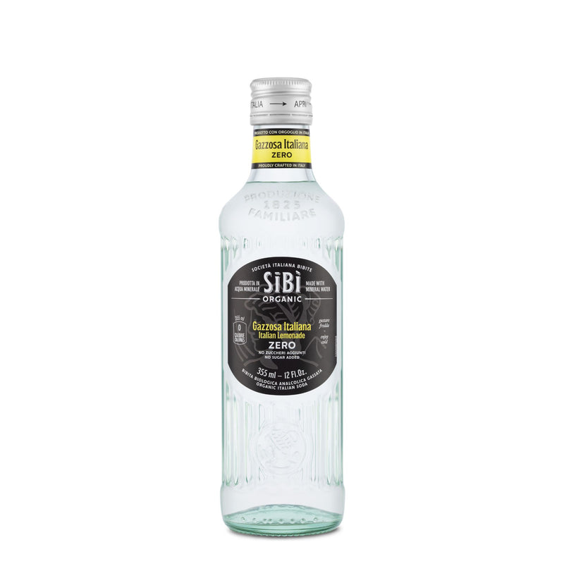 A 355ml clear glass bottle of Sibilla Organic Gazzosa Italiana Zero (Lemon-Lime Soda) with a black label, silver cap, embossed details, and Italian product info. This zero-sugar Italian soda is refreshing and organic.