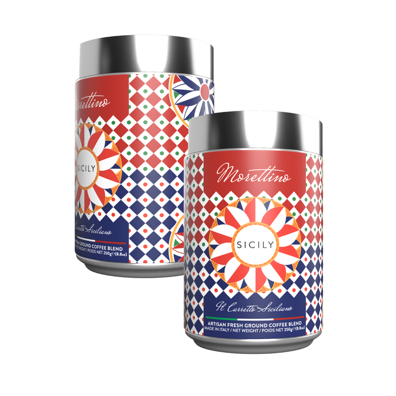 Two vibrant Morettino Boutique Sicilian Carretto coffee tins (250g) feature geometric red, blue, and white designs with shiny silver lids. Each upright tin showcases Sicilian style and contains premium ground coffee.