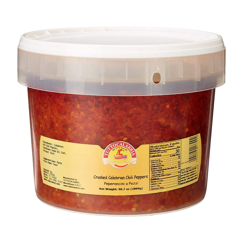 Tutto Calabria Crushed Hot Chili Peppers, Restaurant Size (98.7 oz), come in a plastic tub with a clear lid and yellow label displaying product info, nutrition facts, and the Tutto Calabria brand logo for authentic Italian spice.